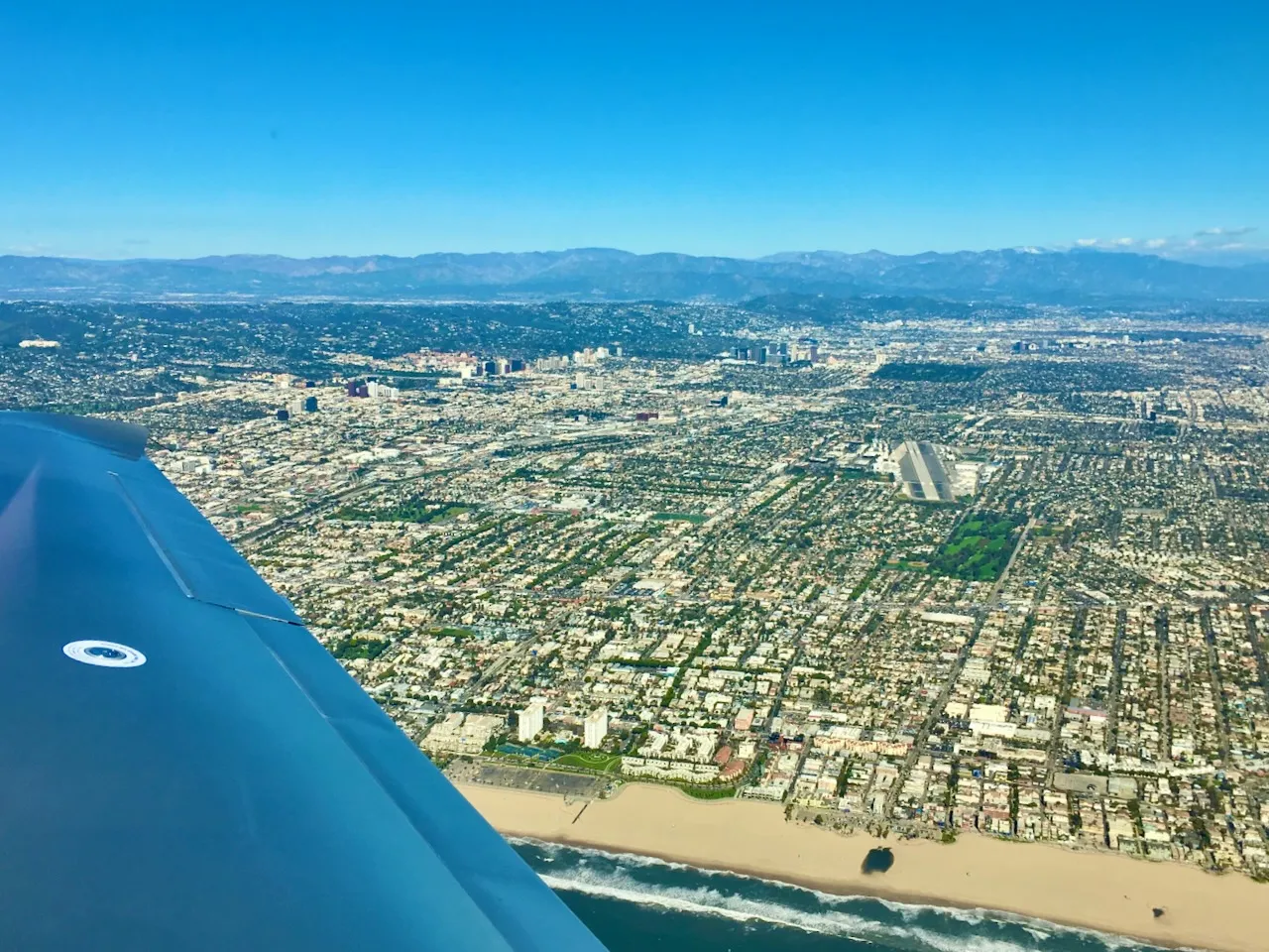 Base turn at Santa Monica - LA skyline and beach sprawl from above