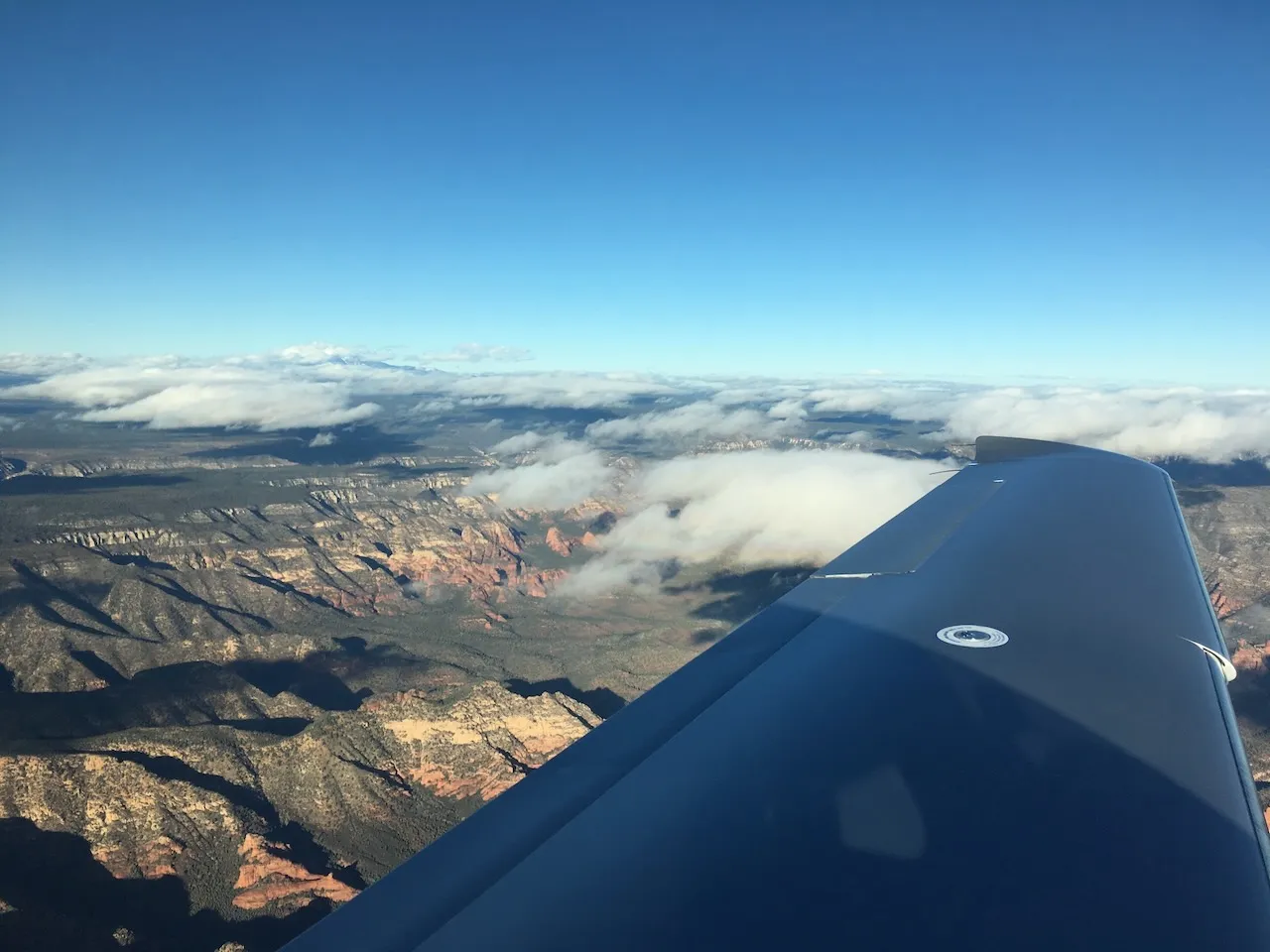 Approaching Sedona - red rock formations emerging through scattered clouds